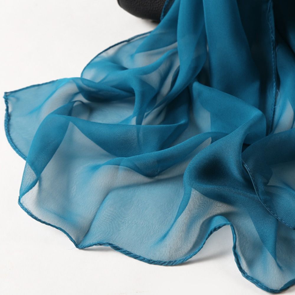 Teal chiffon scarf close-up showing sheer fabric texture and rolled edges