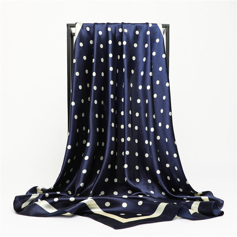Navy blue polka dot silky square scarf draped on display showing drape and length