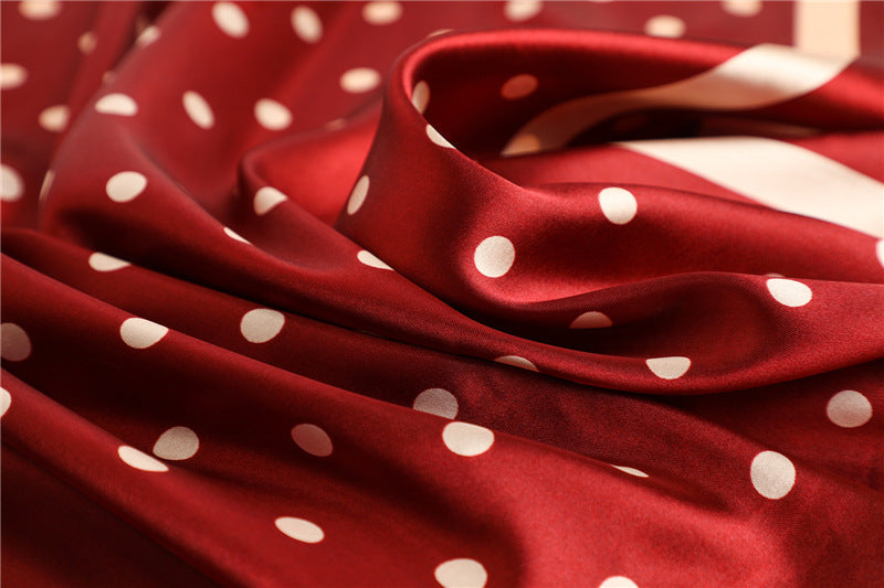 Black and white polka dot silk-feel satin square scarf draped on handbag