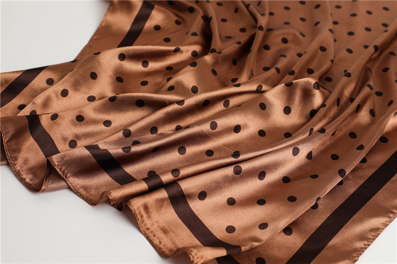 Red and white polka dot silk-feel satin scarf close-up showing fabric texture and sheen