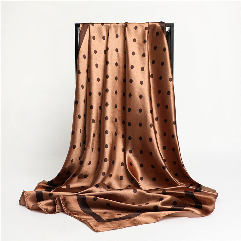Close-up of cognac brown polka dot silk-feel scarf showing satin texture and dark chocolate dot print