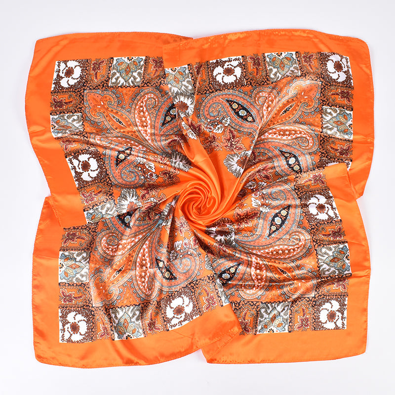 Orange paisley floral silk-feel square scarf flat lay showing full print and satin sheen