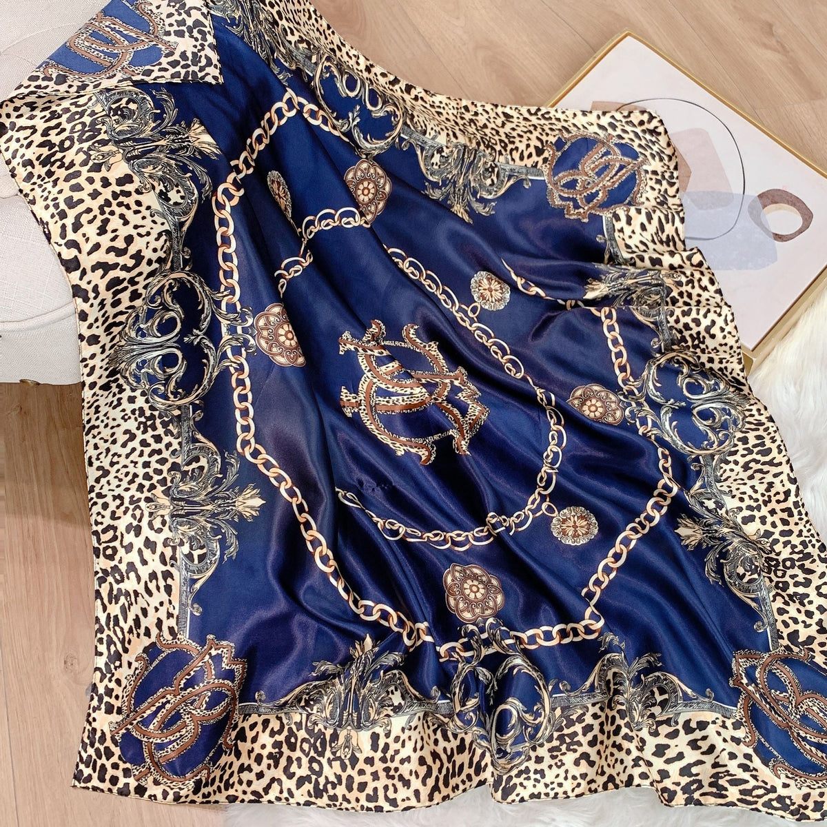 Close-up of navy blue baroque chain and leopard print silk-feel square scarf laid flat