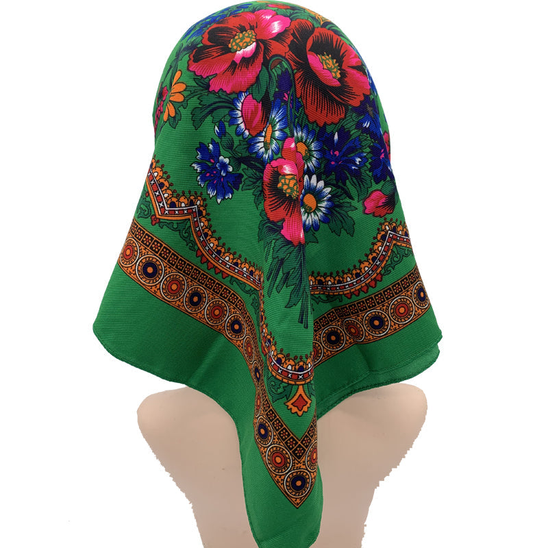 Green floral square scarf worn as headscarf showing vibrant folk floral print