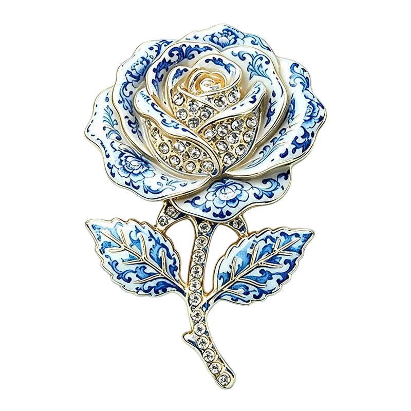Green leaf brooch with three elongated emerald enamel leaves on white ceramic surface