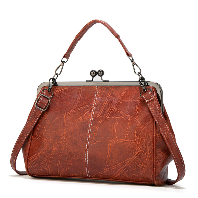 Front view of vintage kiss-lock crossbody bag with adjustable strap and antique gunmetal hardware