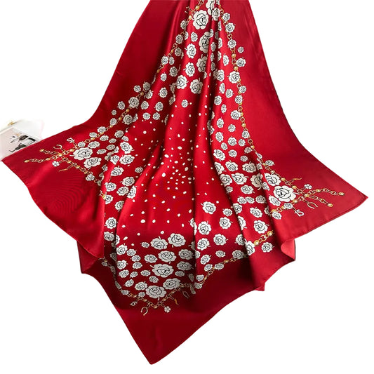 Crimson camellia rose square scarf draped over leather sofa showing full 90cm square size and print layout