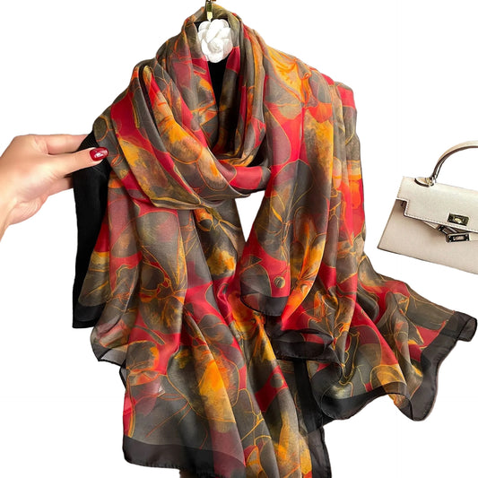 Autumn ember floral silk-feel wrap scarf in crimson, gold, and charcoal — draped and knotted view