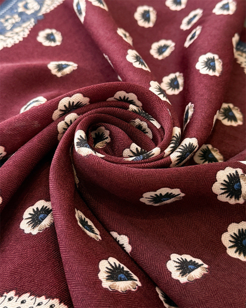 Burgundy floral scarf draped showing cream floral motifs and dusty blue paisley border detail