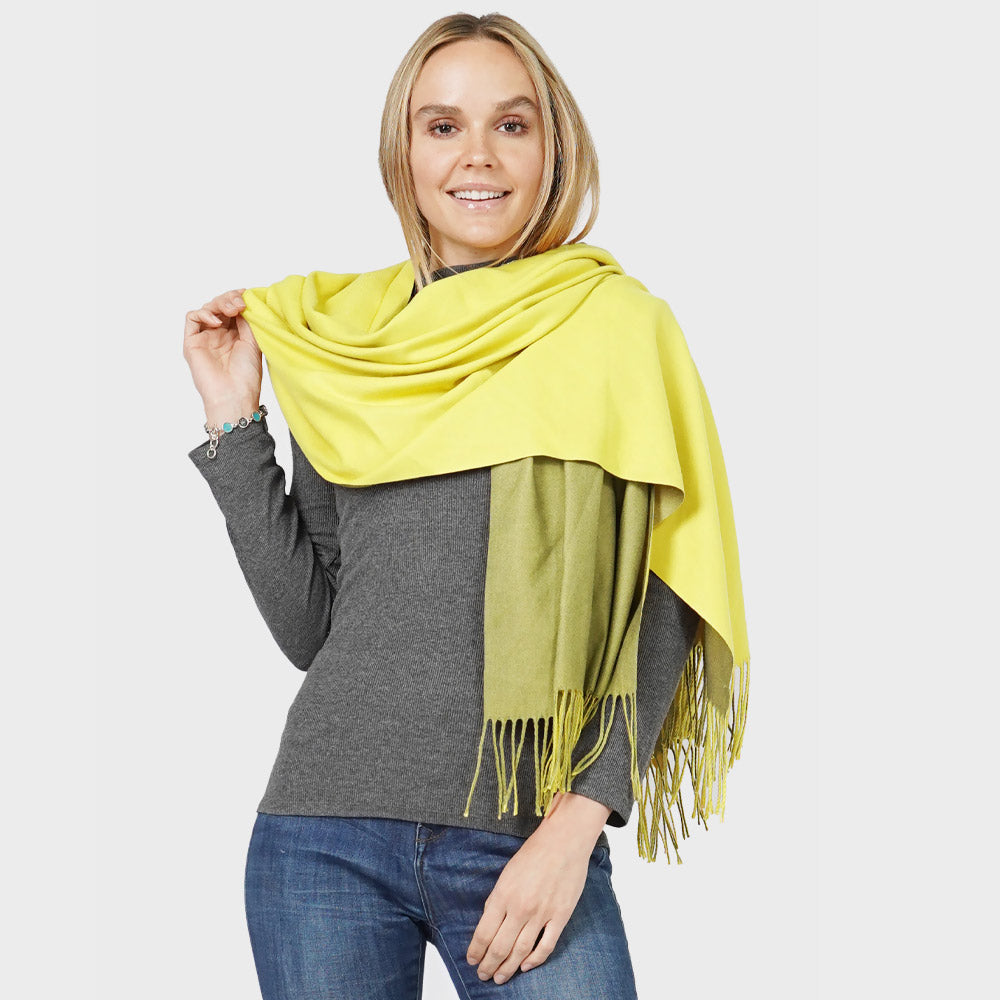 Women's yellow to olive green ombre viscose oversized wrap shawl scarf with fringe trim, worn draped over shoulders