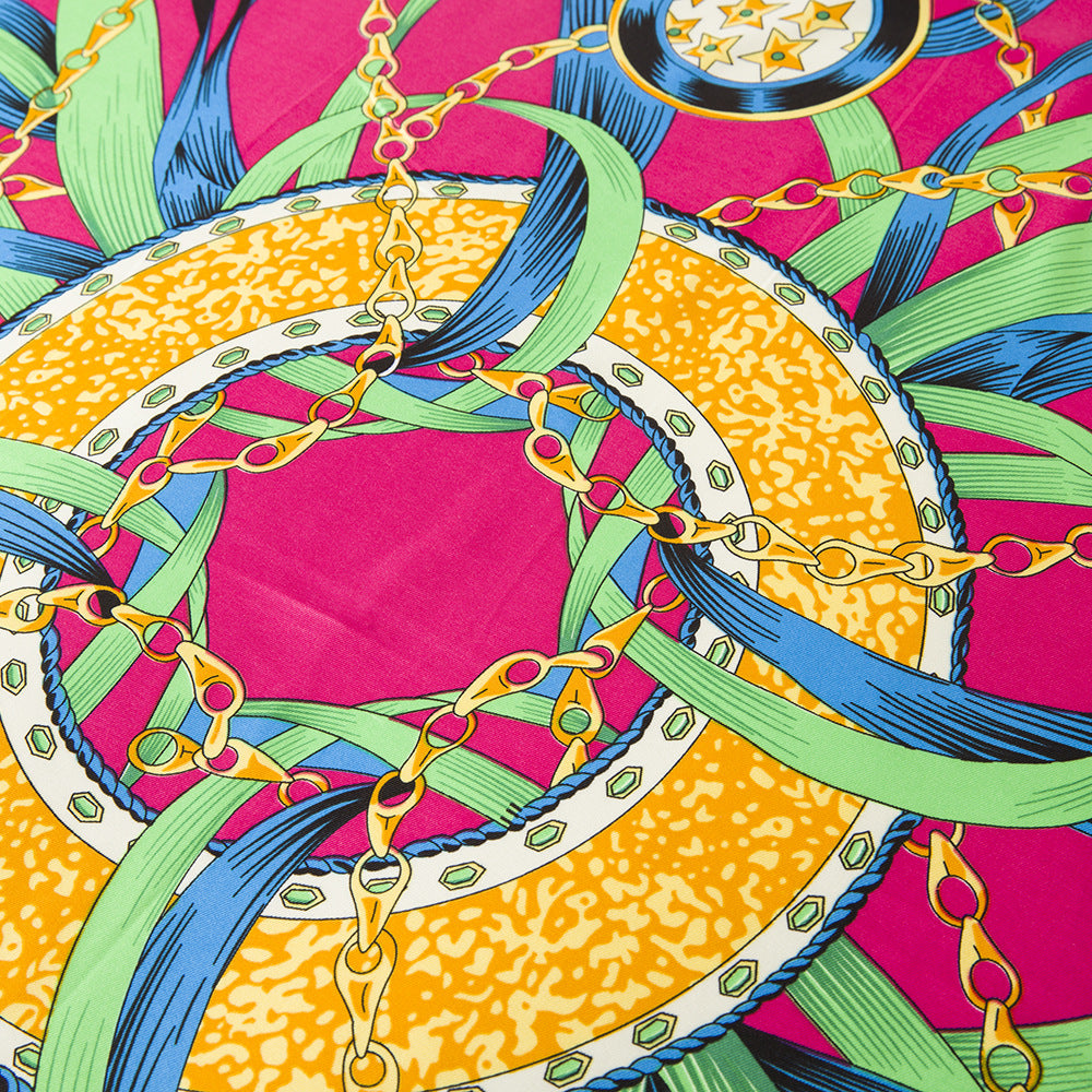 Full flat lay of fuchsia silk square scarf with chain tassel and medallion print