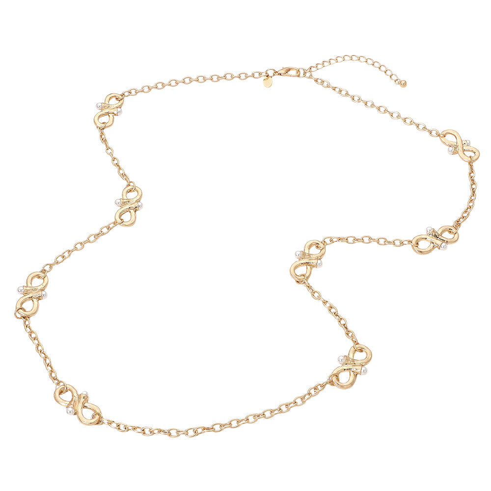 Woman wearing long gold infinity station necklace with pearl accents over a grey blouse
