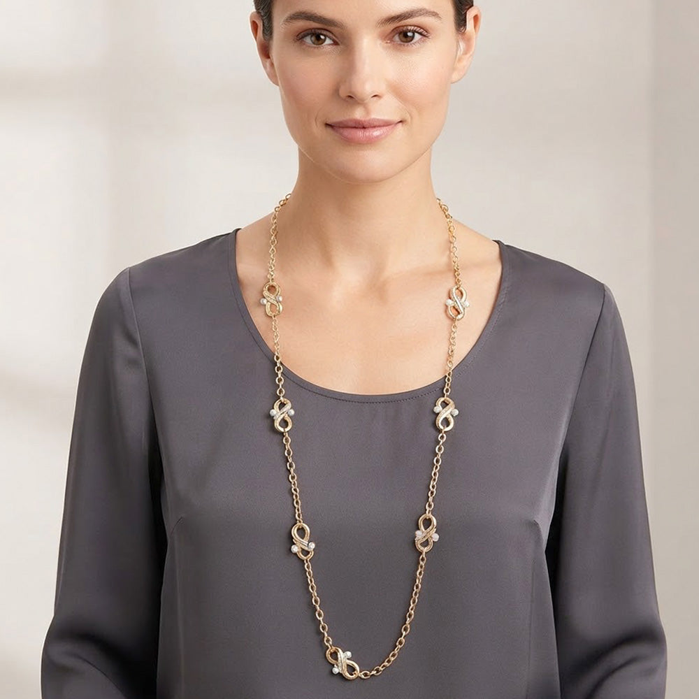 Long gold infinity station necklace with pearl accents on white background showing full length and lobster clasp extender