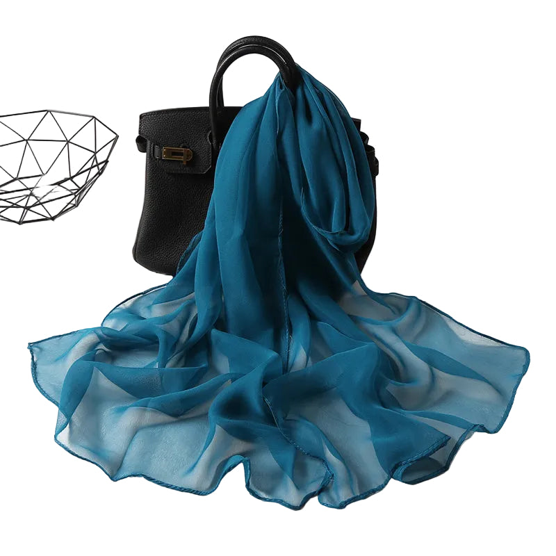 Teal ocean blue solid chiffon-feel scarf draped over black handbag