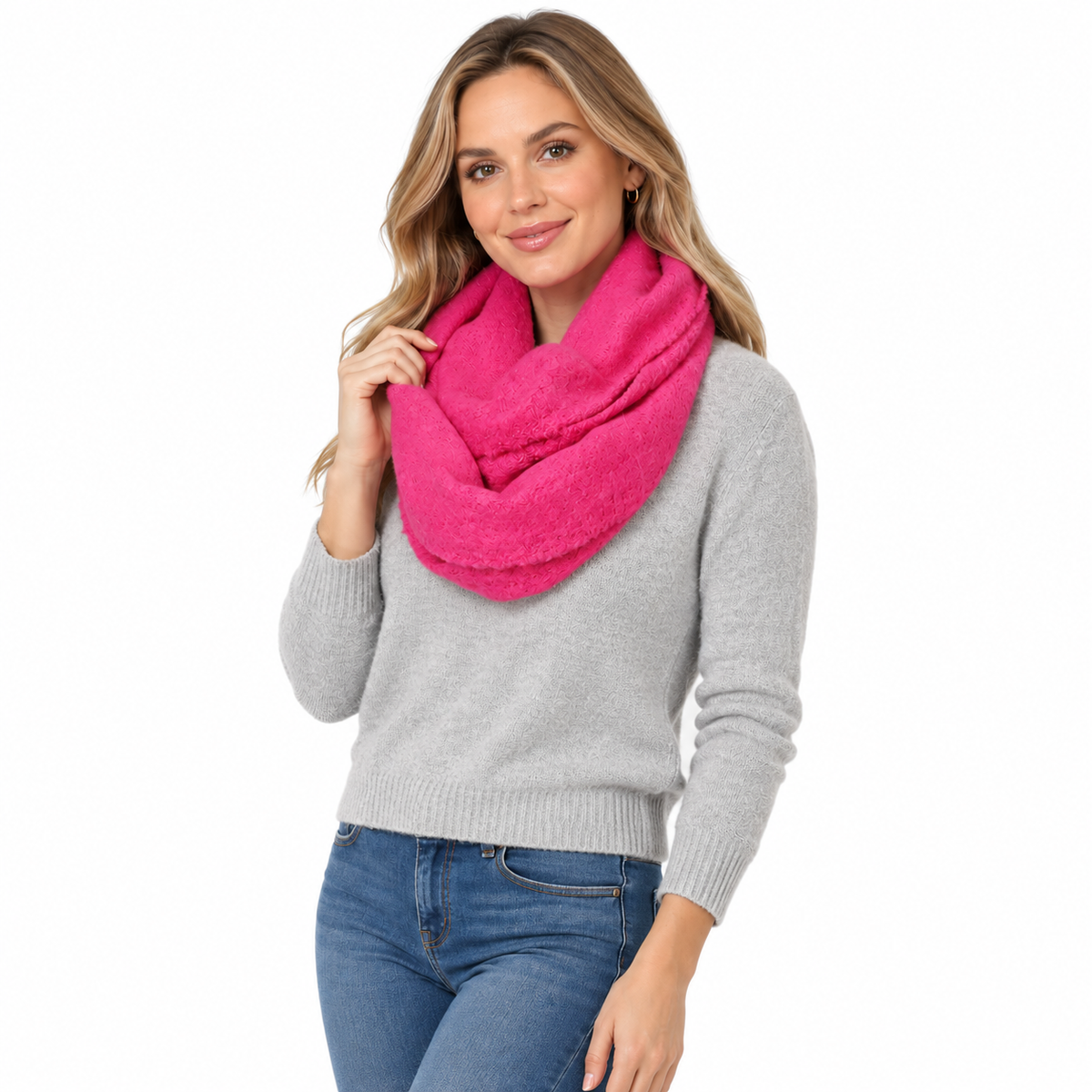 Woman wearing hot pink chunky knit infinity scarf over grey sweater and jeans, front view