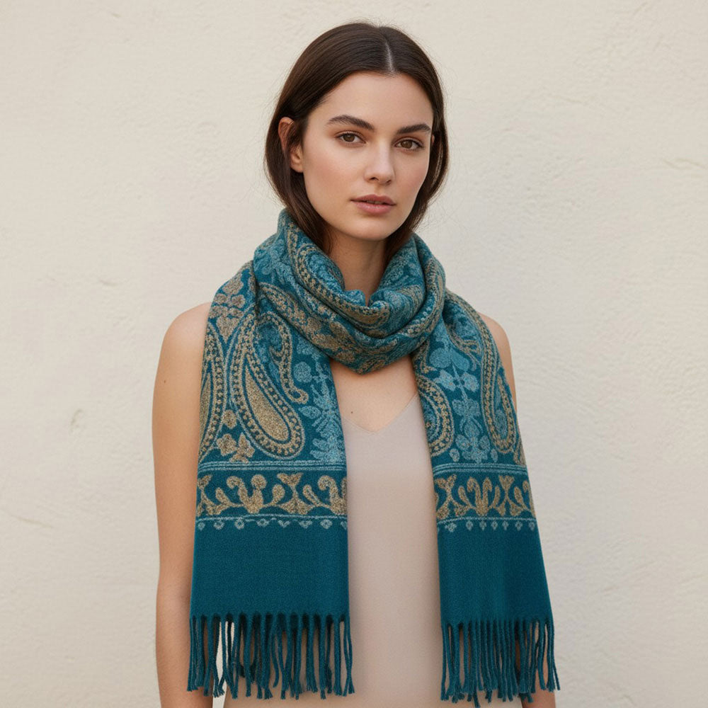 Woman wearing teal paisley embroidered scarf wrapped around neck against neutral wall
