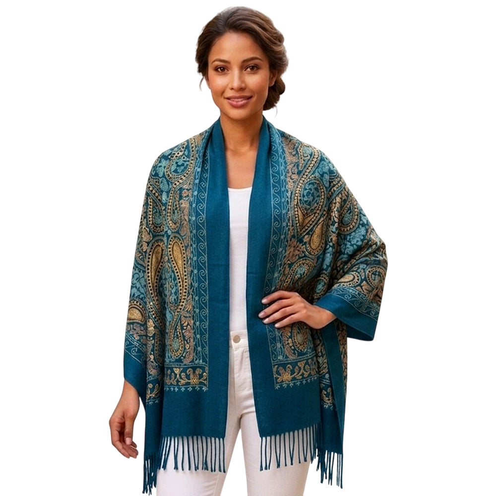 Teal paisley fringe scarf styled in a loop on white surface next to coffee cup
