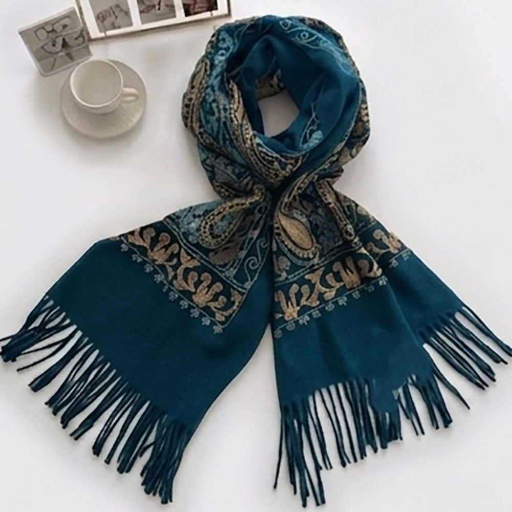 Woman wearing teal paisley shawl wrap draped over shoulders with white top and jeans