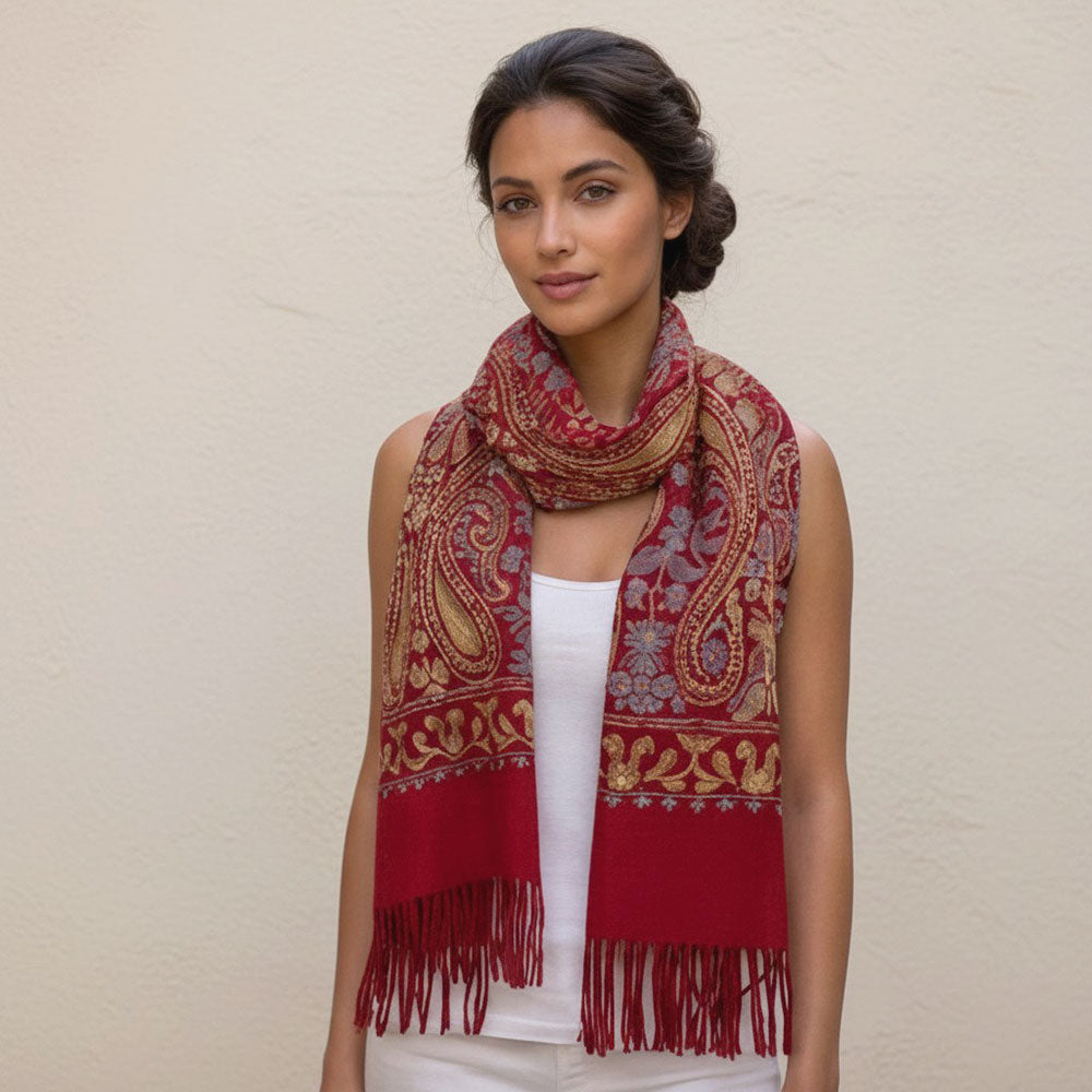 Crimson red paisley embroidered scarf wrap looped and laid flat on white surface showing fringe tassels and gold embroidery detail