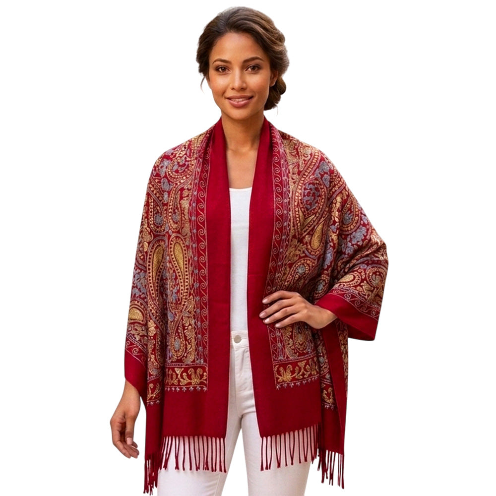 Woman wearing crimson paisley embroidered scarf wrap as an open shawl draped over shoulders, white background
