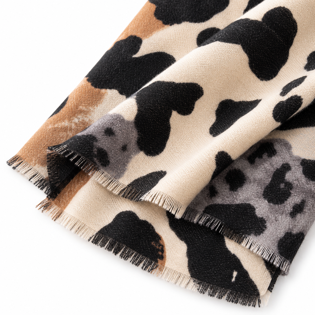 Women's oversized animal print scarf beige black cashmere feel – close-up of mixed abstract animal spot print with tan, gray and black tones and fringe edge detail