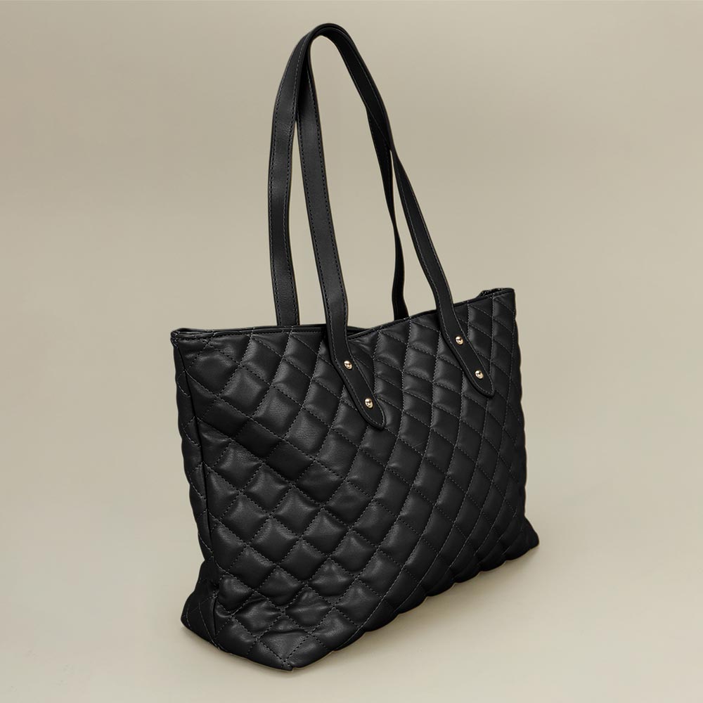 Black quilted tote bag side angle view showing 5.2 inch depth and magnetic closure at top