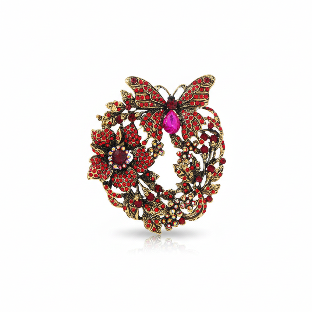 Front product view of antique gold-tone butterfly floral wreath brooch with red rhinestones and magenta accent